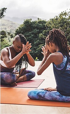 two women wearing athleta top and bottoms doing yoga