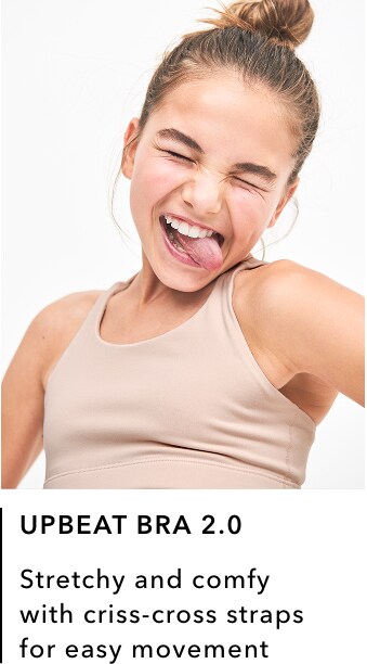 girl wearing tan Upbeat Bra 2.0: Stretch and comfy with criss-cross straps for easy movement.