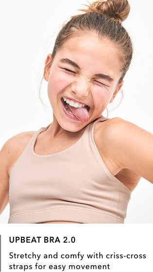 girl wearing tan Upbeat Bra 2.0: Stretch and comfy with criss-cross straps for easy movement.